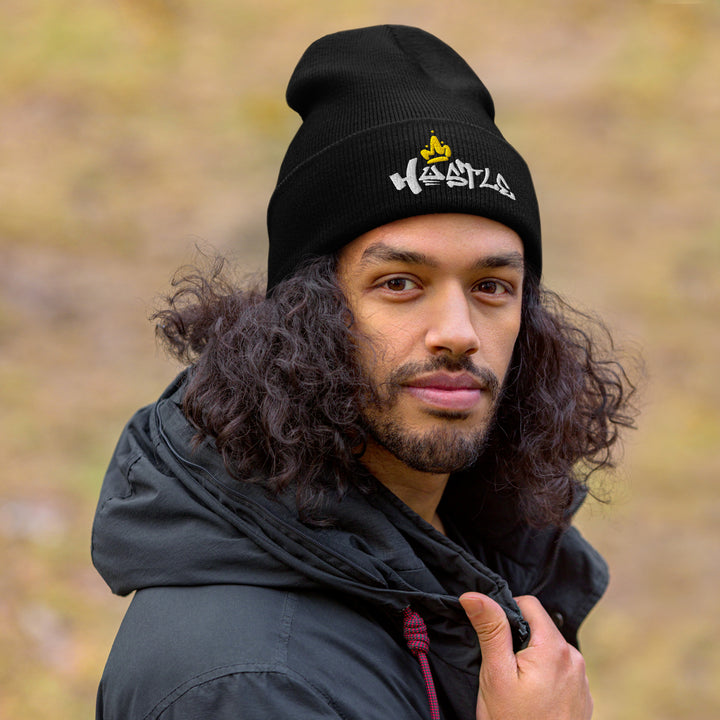 A modern man in a jacket is wearing the Embroidered Hustle King Theme Cuffed Beanie.