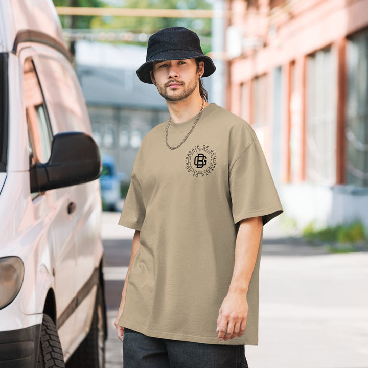 An urban man in the streets is wearing the Breath Of God Concept Tee, front view.