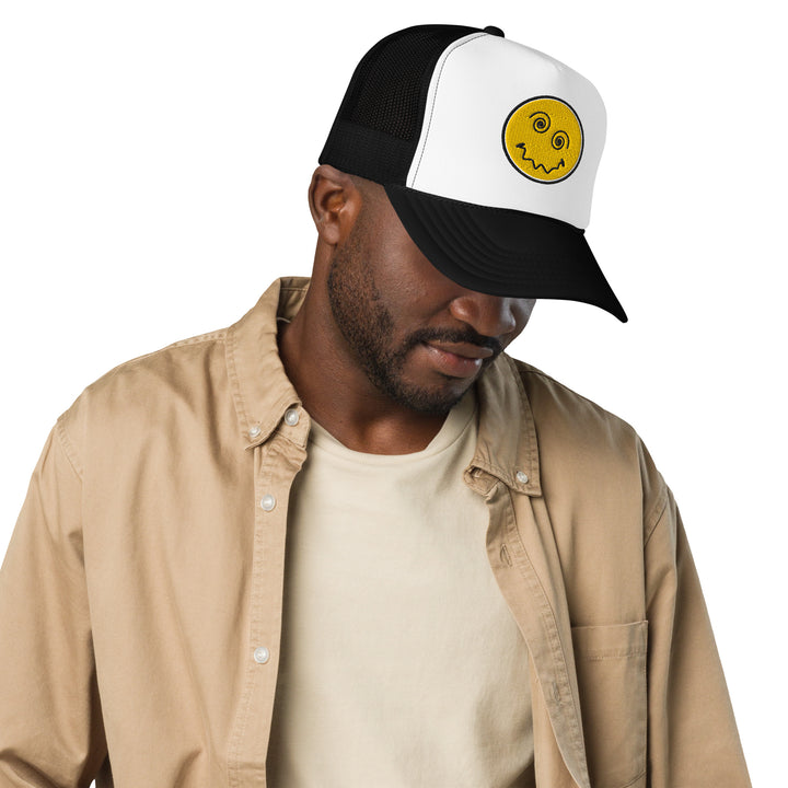 An urban man in the studio is wearing the Anxiety Face Embroidered Foam Trucker Hat, front view.