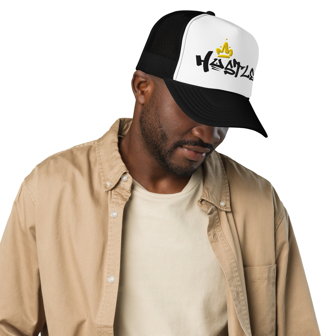 An urban man is wearing the Hustle King Theme Embroidered Foam Trucker Hat, front view.