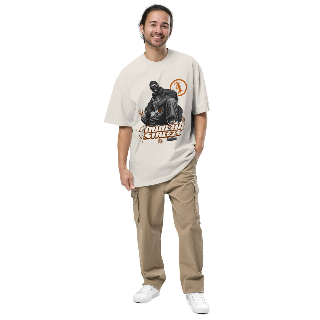 An urban man is wearing the Men's I Own The Streets Theme Oversized Faded Tee, front view.